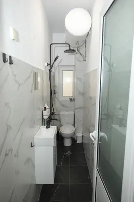a white bathroom with a toilet and a sink at Уютна къща в сърцето на София in Sofia