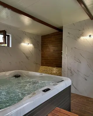 a bathroom with a large tub with green water at Къща за гости Алегра in Garmen
