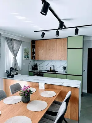 a kitchen with a wooden table with chairs and a counter at Къща за гости Алегра in Garmen