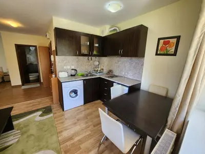 a kitchen with a table and a washing machine at Pine tree Easy Ski access - Next 100m to Ski slope and forest view in Bansko