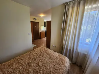 a bedroom with a large window and a rug at Pine tree Easy Ski access - Next 100m to Ski slope and forest view in Bansko