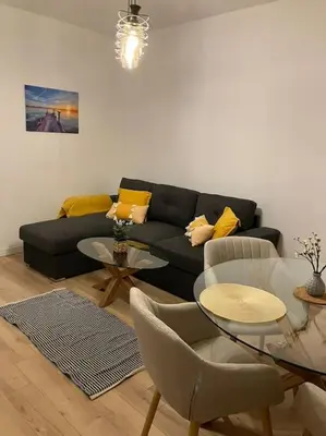 a living room with a black couch and a table at Apartament Aleksandar Premium in Kyustendil