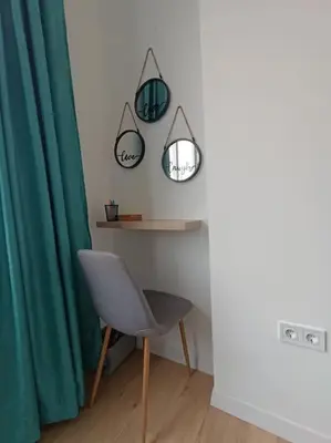 a room with a chair and a table and a mirror at Apartament Aleksandar Premium in Kyustendil