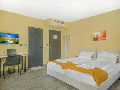 a bedroom with a bed and a desk and a computer at Хостел Стадиона in Pazardzhik