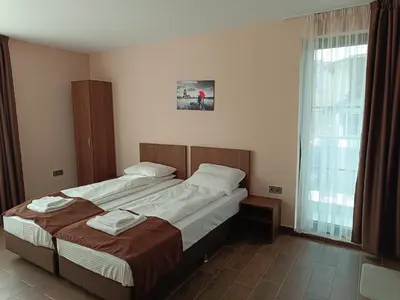 a bedroom with two beds and a large window at Хостел Стадиона in Pazardzhik