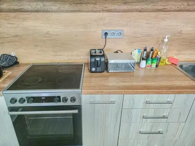 a kitchen with a counter with a stove and a counter top at Хостел Стадиона in Pazardzhik