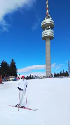 a person on skis in the snow in front of a tower at Апартамент за гости 2Б14 Grand Monastiry in Pamporovo