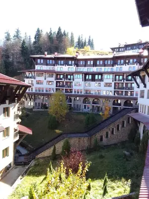 a large white building with trees in the background at Апартамент за гости 2Б14 Grand Monastiry in Pamporovo