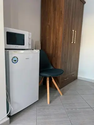 a black chair sitting next to a microwave on top of a refrigerator at B8 Luxury Studio Apartment in Green Life Bansko in Bansko