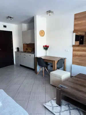 a living room with a table and a kitchen at B8 Luxury Studio Apartment in Green Life Bansko in Bansko