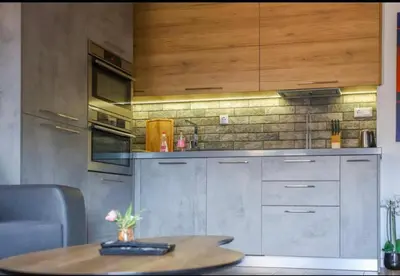 a kitchen with wooden cabinets and a table at Luxury Apartment Rich 3 in Velingrad