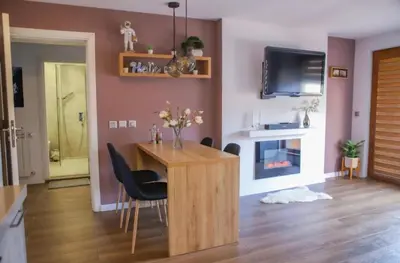 a living room with a wooden table and chairs at Luxury Apartment Rich 3 in Velingrad