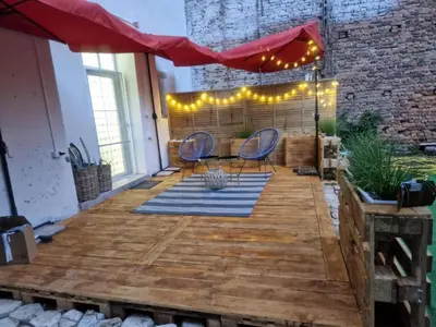 a patio with a table and chairs and lights at La Maison des Fleurs FREE PARKING in Pazardzhik