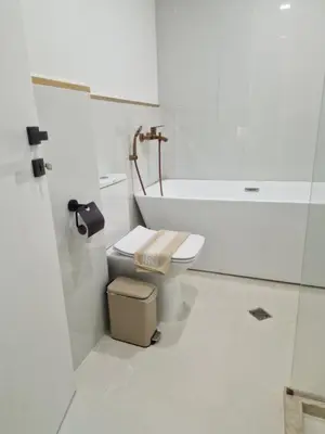 a white bathroom with a toilet and a bath tub at La Maison des Fleurs FREE PARKING in Pazardzhik