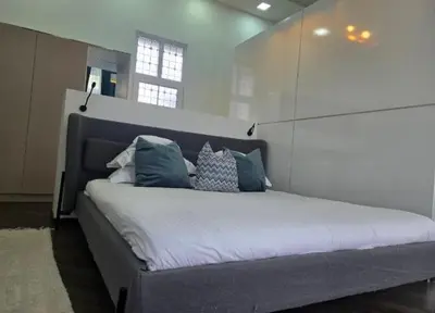 a bedroom with a large bed with blue and white pillows at La Maison des Fleurs FREE PARKING in Pazardzhik