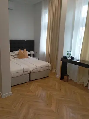 a bedroom with a bed and a wooden floor at La Maison des Fleurs FREE PARKING in Pazardzhik