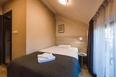 a bedroom with a bed with two towels on it at Hotel Avalon Kyustendil in Kyustendil