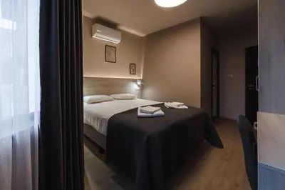 a bedroom with a bed with a table with towels on it at Hotel Avalon Kyustendil in Kyustendil