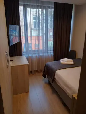 a hotel room with a bed and a window at Hotel Avalon Kyustendil in Kyustendil
