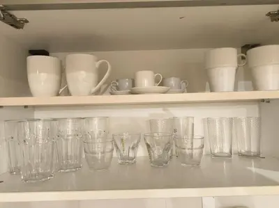 a row of empty glasses on a shelf at Mycampus 1 bdrm, stay 4, free parking, garden, self check-in in Sofia