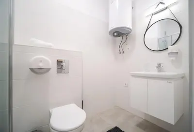 a white bathroom with a toilet and a sink at Mycampus 1 bdrm, stay 4, free parking, garden, self check-in in Sofia
