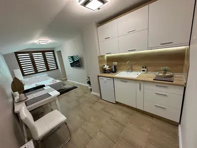 a kitchen with white cabinets and a sink at Guest House Doni in Sandanski