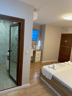 a bedroom with a bed and a glass shower at Guest House Doni in Sandanski