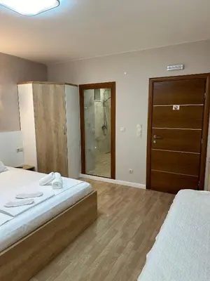 a bedroom with a bed and a wooden door at Guest House Doni in Sandanski