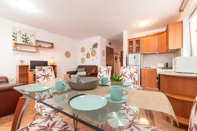a kitchen and living room with a glass table in a room at Mountain View Apartment with Balcony & Ski Access nearby - Serendipity in Bansko