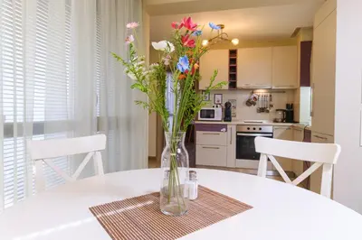 a vase with flowers on a table in a kitchen at Riverside 2-Bedroom Apartment in Plovdiv