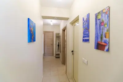 a hallway with paintings on the walls at Riverside 2-Bedroom Apartment in Plovdiv