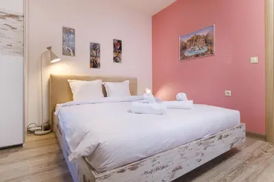 a bedroom with a large bed with white sheets at Riverside 2-Bedroom Apartment in Plovdiv