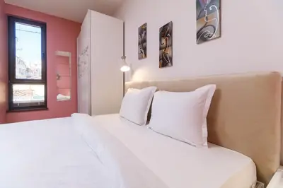 a bedroom with a white bed with white pillows at Riverside 2-Bedroom Apartment in Plovdiv