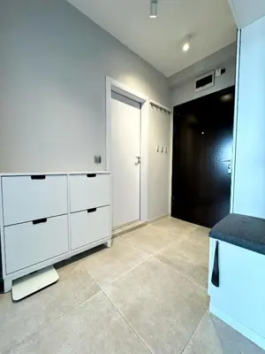 a kitchen with white cabinets and a black door at Central Apartment with Amazing Views in Sofia