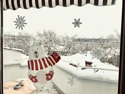 a snowman statue sitting on a window sill with a snow covered roof at Bellevue Appart Centrum in Plovdiv
