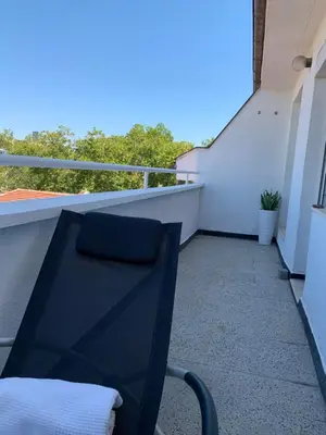 a black chair sitting on the balcony of a building at Bellevue Appart Centrum in Plovdiv