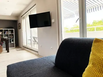 a living room with a couch and a flat screen tv at Bellevue Appart Centrum in Plovdiv
