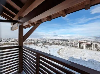 a view of a snowy city from a balcony at Panoramic 2 Bedroom Cabin Retreat Japanese Style in Bansko