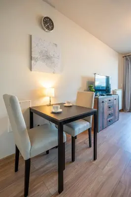 a dining room table with two chairs and a lamp at Palitra Studio in Sofia