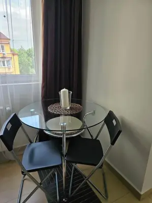 a glass table with two chairs and a candle on it at Family Suite in Sofia