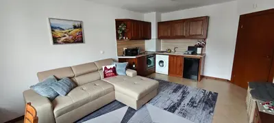 a living room with a couch and a kitchen at Bansko Pirin Golf & Country Club Blue Mountains View in Razlog