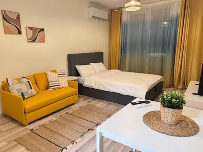 a living room with a bed and a yellow couch at Studio 108 by COSHER in Sofia