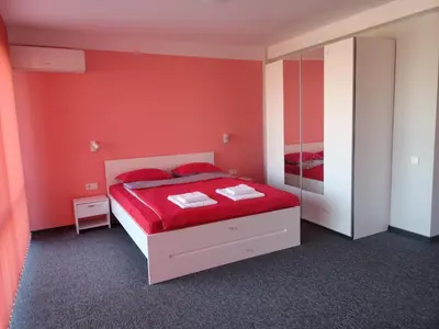 a red bedroom with a bed and a mirror at Ubis Hotel in Krumovo