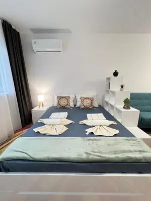 a bedroom with a large bed with pillows on it at Santorini modern and cosy Apt near UNSS and NSA w WiFi in Sofia