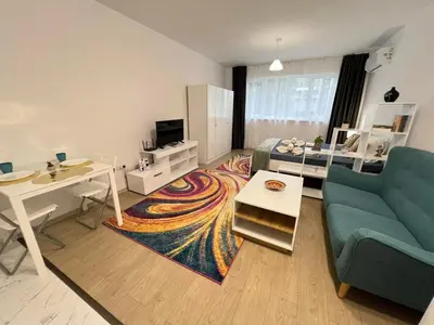 a living room with a couch and a table at Santorini modern and cosy Apt near UNSS and NSA w WiFi in Sofia