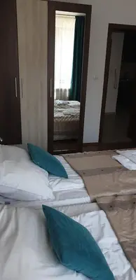a bedroom with two beds with blue pillows in front of a mirror at Apartments Belvedere B303 in Bansko