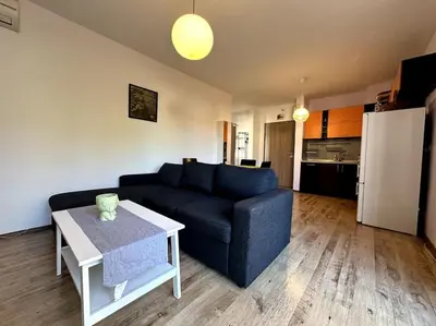 a living room with a blue couch and a table at Cozy flat in central Sofia in Sofia