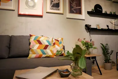 a living room with a couch and a table with a laptop at NEW Oasis in the heart of Sofia in Sofia