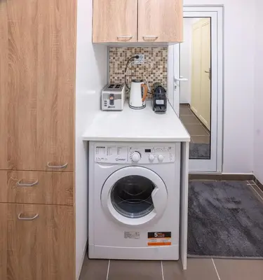 a kitchen with a washing machine with a counter at Ukulele Place in Sofia