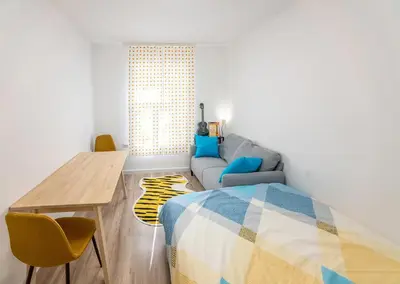 a room with a bed and a table and a couch at Ukulele Place in Sofia